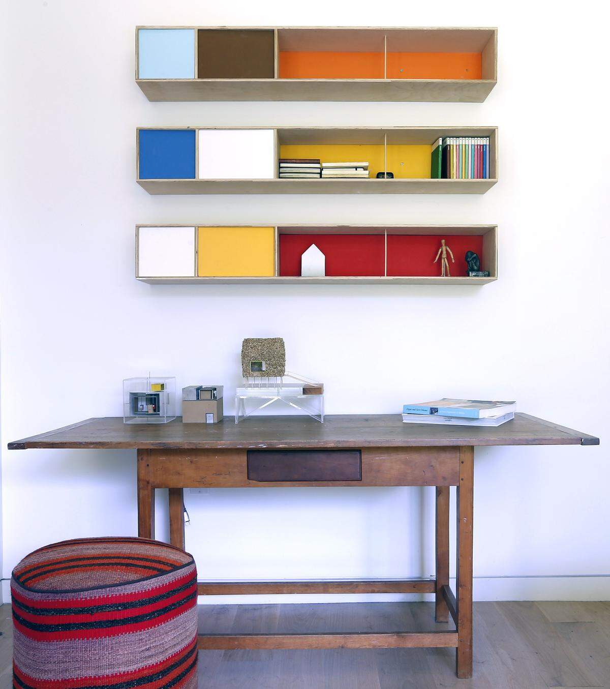 The clean architectural lines are accented with bright touches: cheery porch seating; an entry table; work by architect Jacob Brillhart’s artist sister Jenny, below, and lounges designed by Jacob.