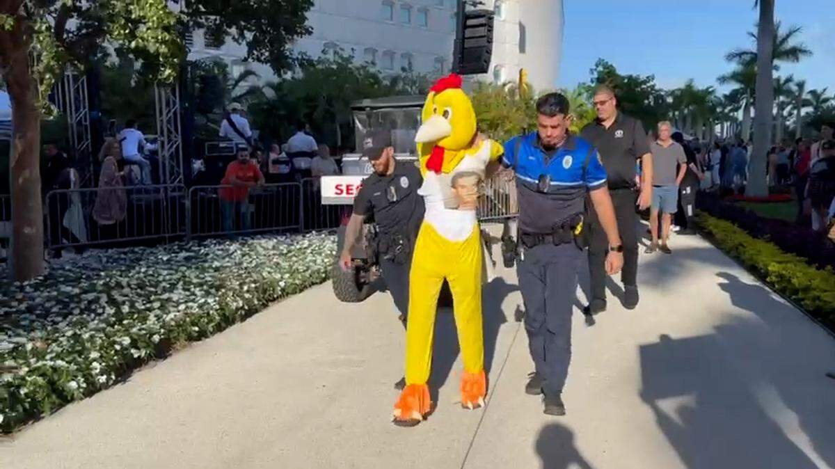 La Policía de Miami aleja a un manifestante disfrazado de pollo en la inauguración el sábado del Dogs & Cats Walkway en el Museum Park de Miami.