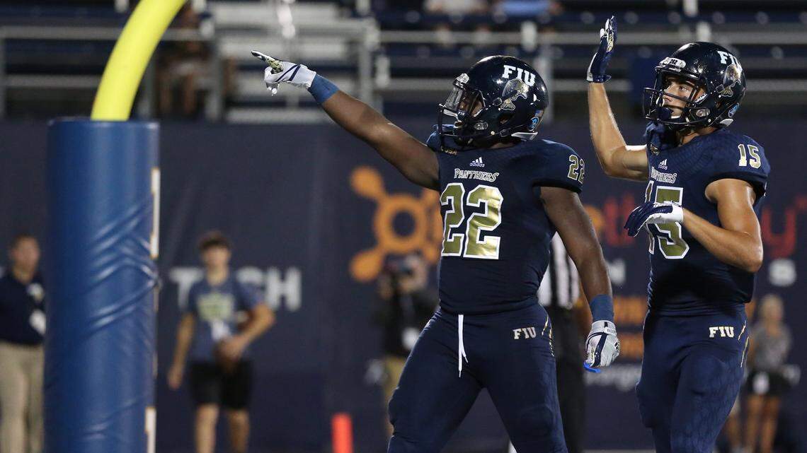 FIU Golden Panthers running back Shawndarrius Phillips (22) and Golden Panthers wide receiver Austin Maloney (15) celebrate in the end zone after Phillips scores in the first half as Florida International University raced to a 42-10 lead in the first half.