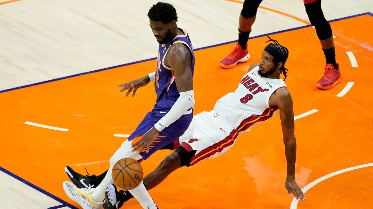 El delantero del Heat Trevor Ariza (8) se enfrenta al centro de los Suns, Deandre Ayton, el martes 13 de abril de 2021, en Phoenix.