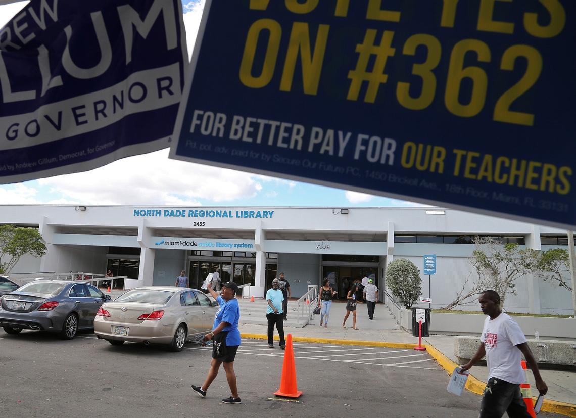 Early voters trickle in to the North Dade Regional Library as poll workers hand out voting materials on Wednesday, Oct. 31, 2018.