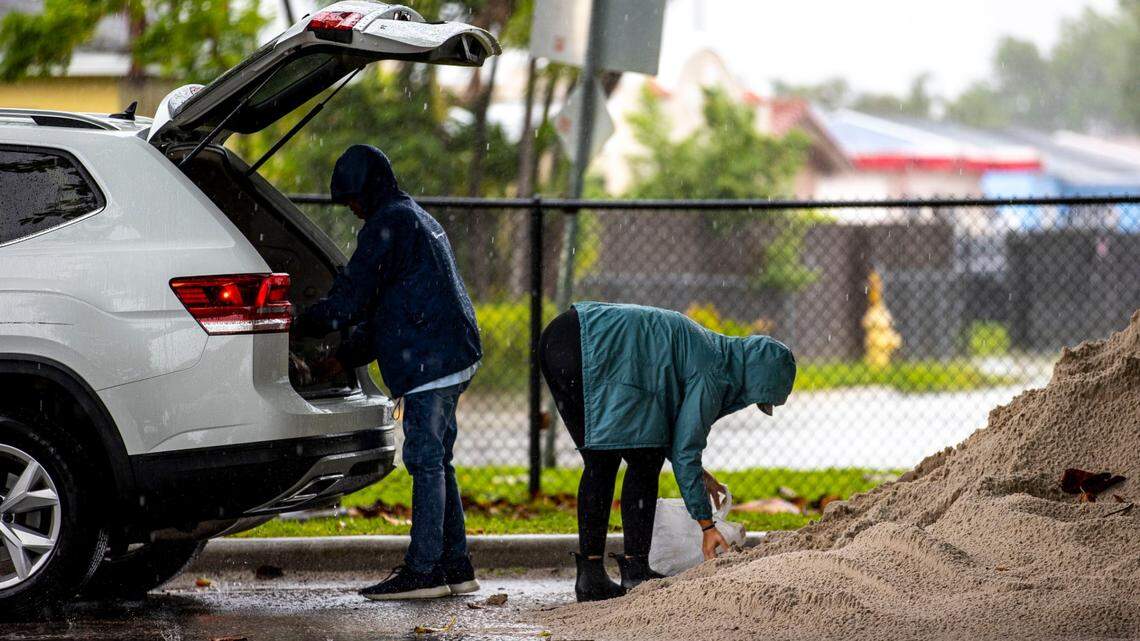 Miami-Dade County residents Jaquelyn Andreu, 28, right, and her father-in-law Frank Andreu, 61, left, pack sand into plastic bags as they prepare for potential flooding at Grapeland Heights Park in Miami, Florida, on Friday, June 3, 2022.
