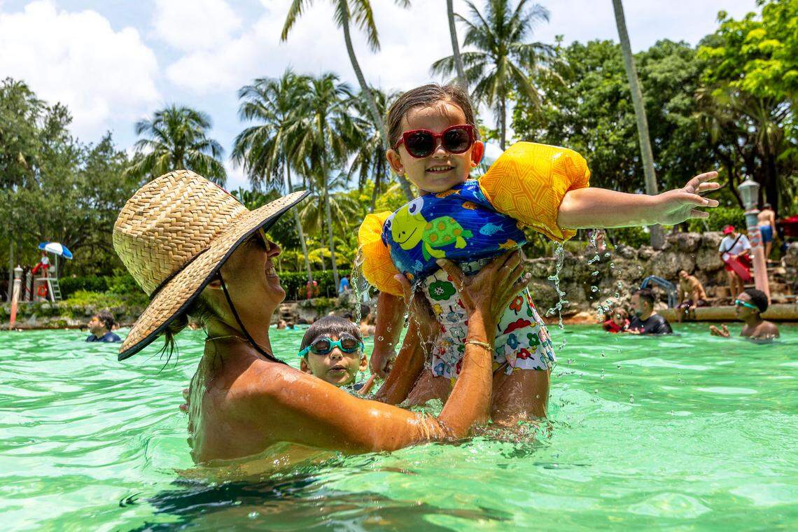 Palmetto Bay resident Claudia Lemus, 41, holds up her daughter Emma, 4, as her son Evan, 8, swims in the background at Venetian Pool on June 28, 2023, in Coral Gables. A temperature of 95 degrees was recorded at the Miami International Airport that day.
