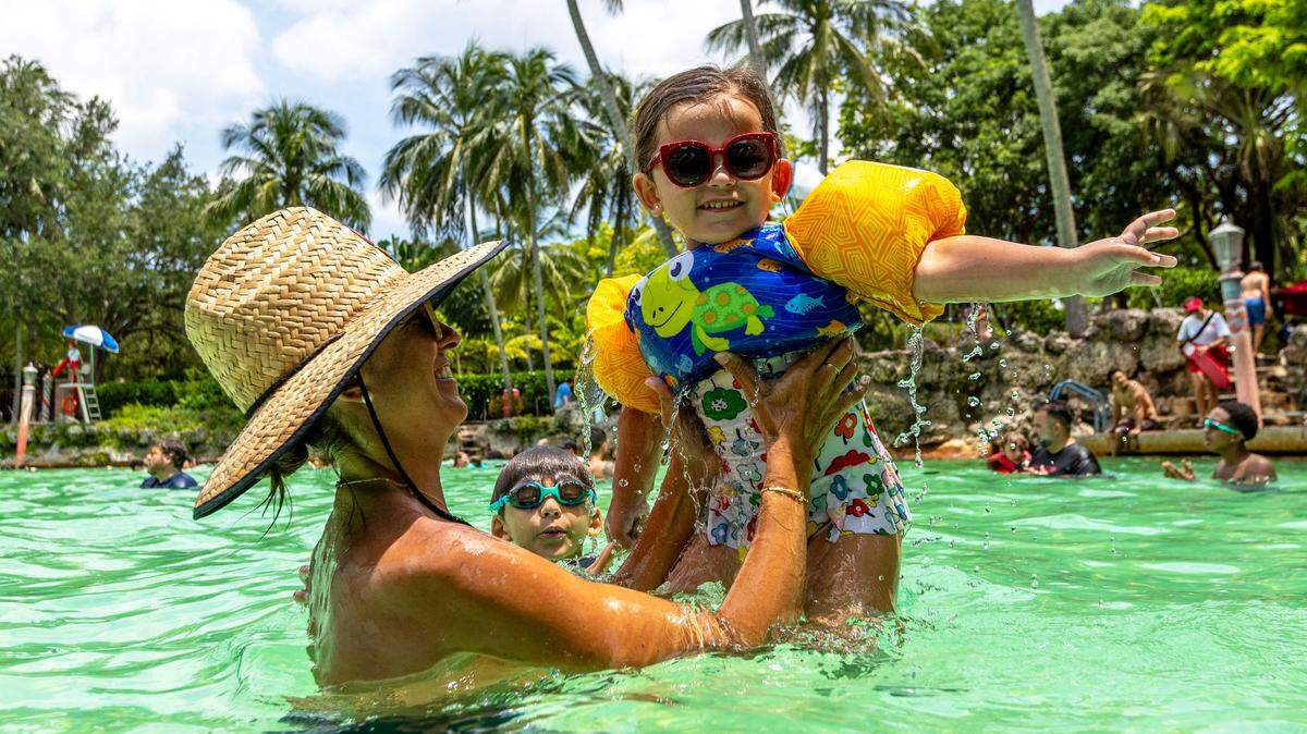 Palmetto Bay resident Claudia Lemus, 41, holds up her daughter Emma, 4, as her son Evan, 8, swims in the background at Venetian Pool on Wednesday, June 28, 2023, in Coral Gables, Florida.