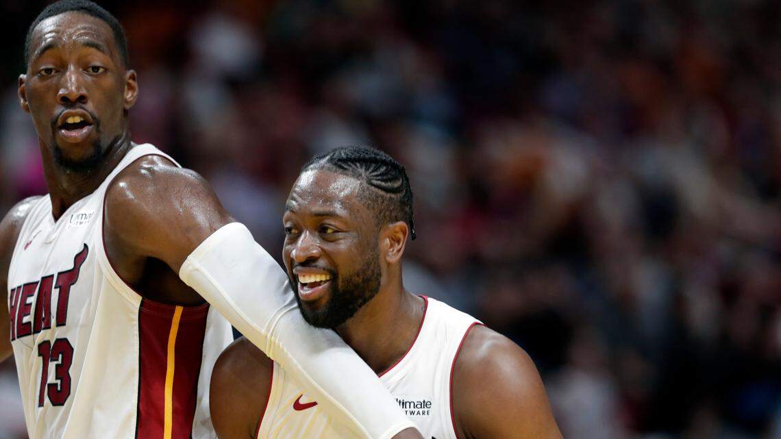 Miami Heat center Bam Adebayo (13) jokes with guard Dwyane Wade during the second half of an NBA basketball game against the Boston Celtics, Wednesday, April 3, 2019, in Miami.