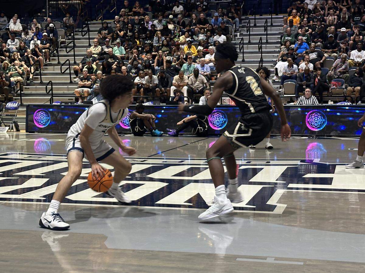 Calvary Christian’s Cayden Daughtry (left) looks to dribble past The Villages defender Jared Thompson during Wednesday night’s Class 3A state championship game at UNF Arena in Jacksonville, Fla.