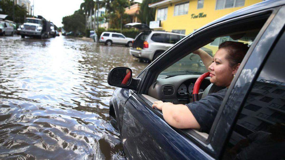 A driver is stranded in her car on a Fort Lauderdale street flooded during king tides.