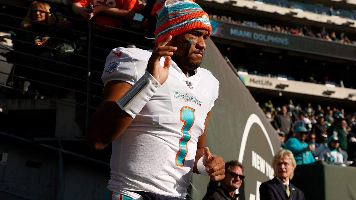 Tua Tagovailoa #1 of the Miami Dolphins waves to the crowd as he enters the stadium before the game against the New York Jets at MetLife Stadium on November 21, 2021 in East Rutherford, New Jersey.