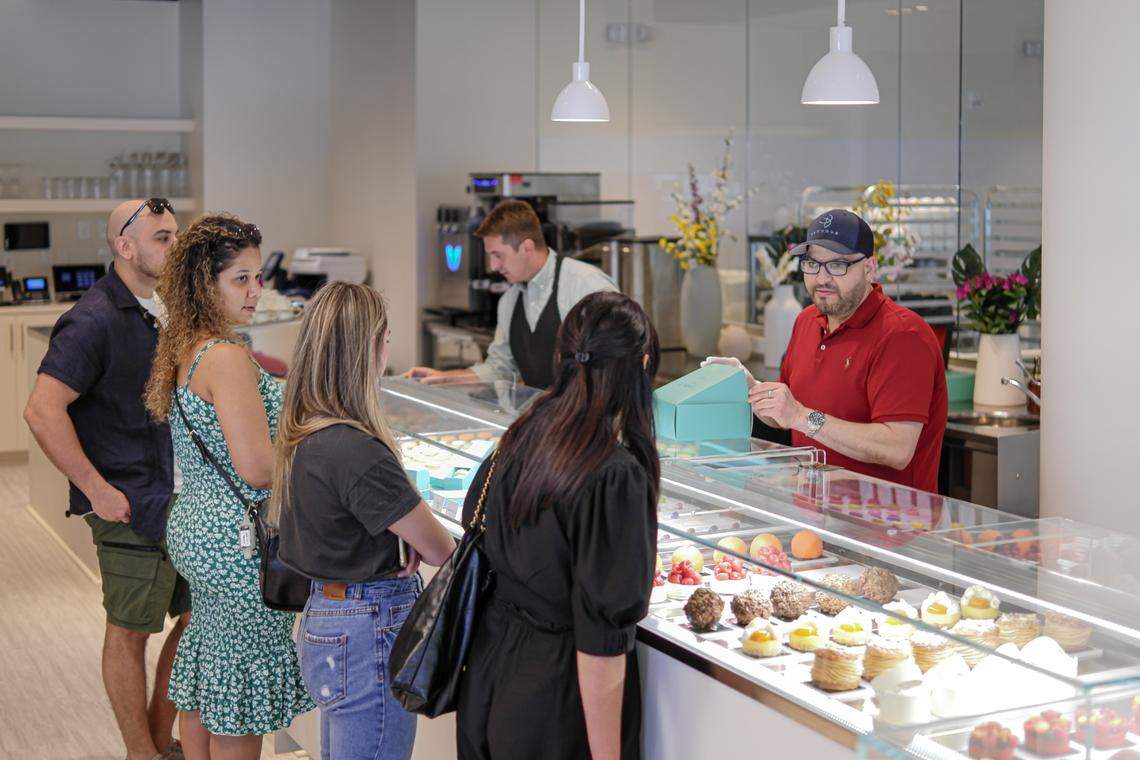 Antonio Bachour, in blue cap, boxes up grab-and-go desserts at the counter at Tablé by Bachour.