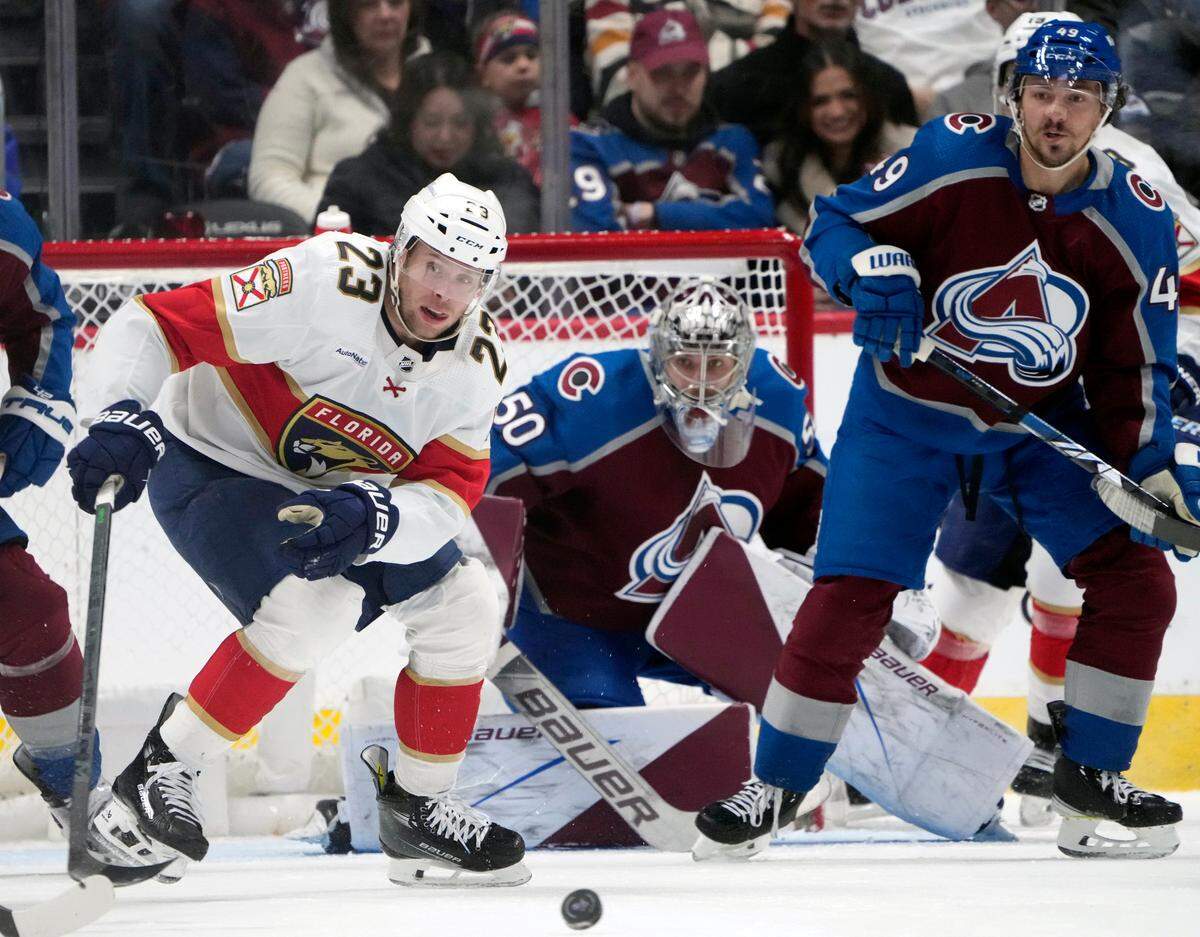 Florida Panthers center Carter Verhaeghe (23) looks for the puck as Colorado Avalanche defenseman Samuel Girard, right, and goaltender Ivan Prosvetov (50) protect the net in the first period of an NHL hockey game Saturday, Jan. 6, 2024, in Denver.