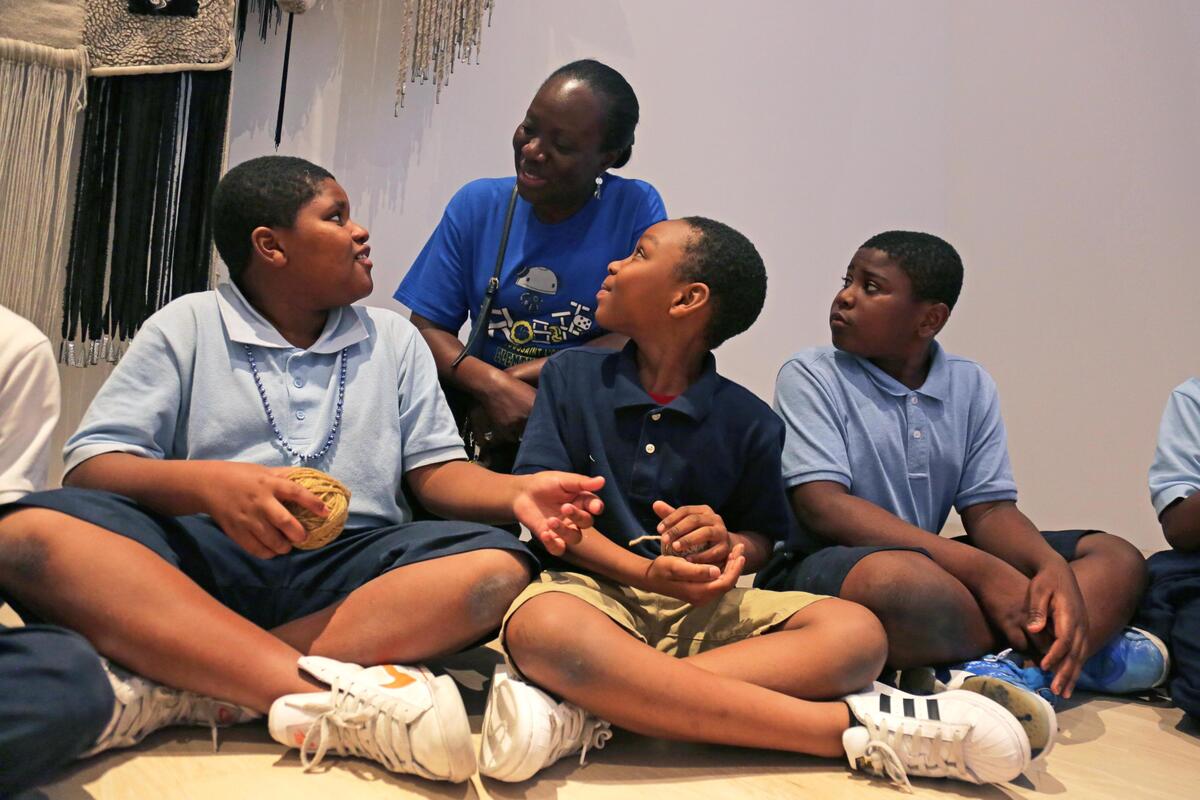 Toussaint L’Ouverture Elementary School teacher Ivana LaFrance, back, talks with fourth grade student as they hold a ball of thread used by Navajo artist Eric-Paul Riege for weaving during a school visit to the institute of Contemporary Art Miami on Tuesday, October 1, 2019.