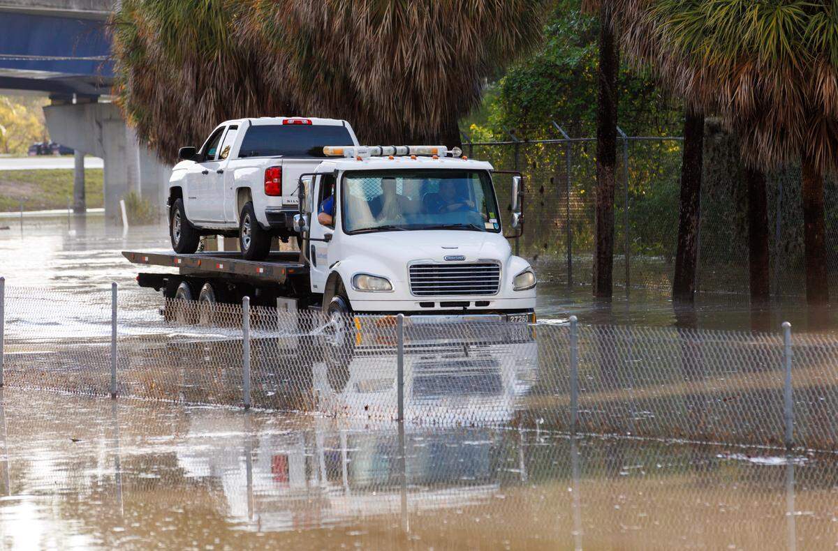 A tow truck drives through the flooded road cause by heavy rains at West Perimeter Road in the Fort Lauderdale on Thursday, April 13, 2023.