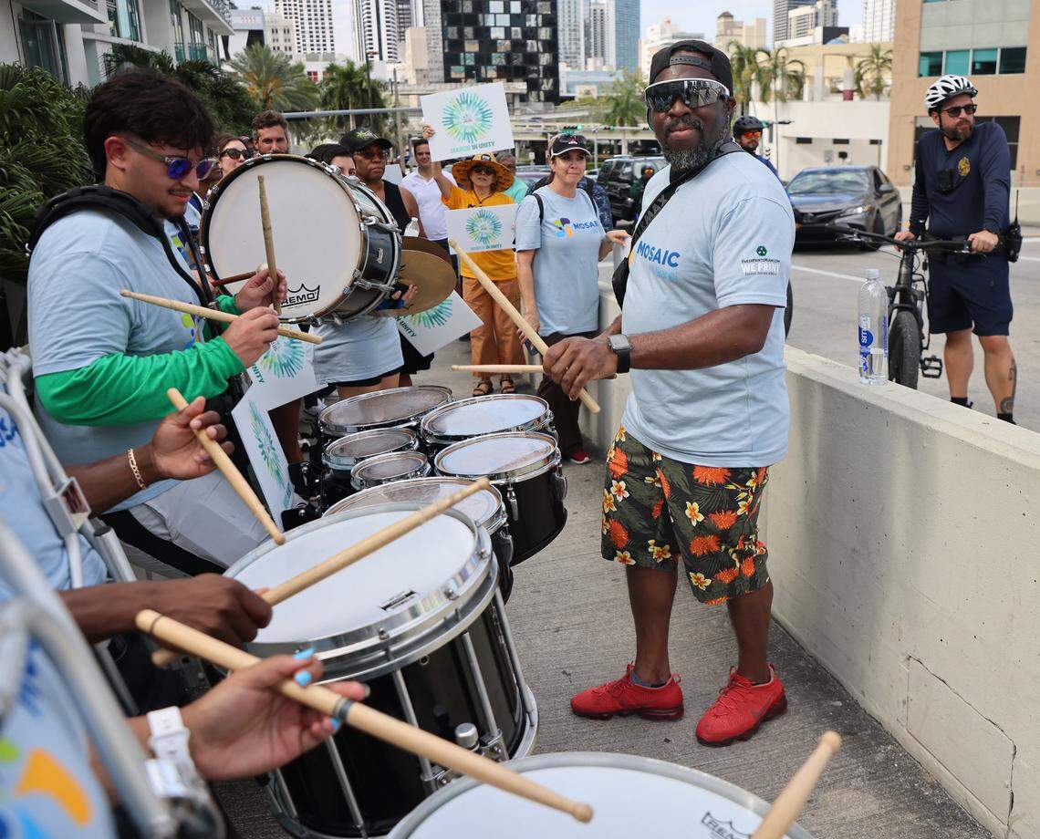 Band leader Eric Levy, center, keep the beat going during a pause in the Miami Unity March that brought together Miami's civic, faith, cultural, and nonprofit communities to reaffirm the importance of unity on Sunday, April 19, 2026, in Miami, Florida. The march stopped as the Miami Avenue drawbridge opened for Miami River traffic.