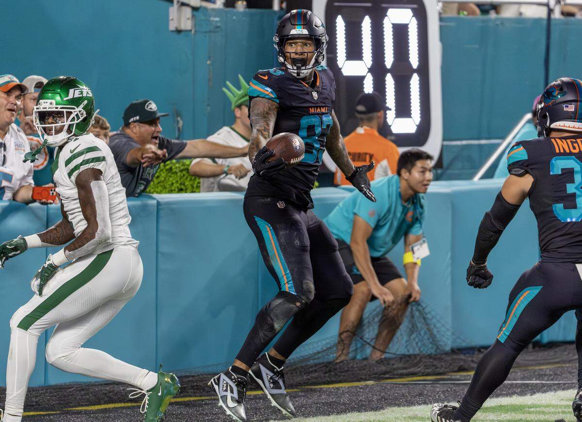 Miami Dolphins tight end Darren Waller (83) reacts after catching a touchdown pass against New York Jets cornerback Sauce Gardner (1) during the first half of an NFL football game Monday, Sept. 29, 2025, in Miami Gardens, Fla.
