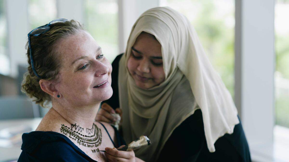 Farah Mehndi tattoos event facilitator Melanie Almeder's own poetry on her upper chest as part of "This Living This Dreaming" poetry workshop and henna session for Sylvester Comprehensive Cancer Center patients. The henna tattoos are temporary.