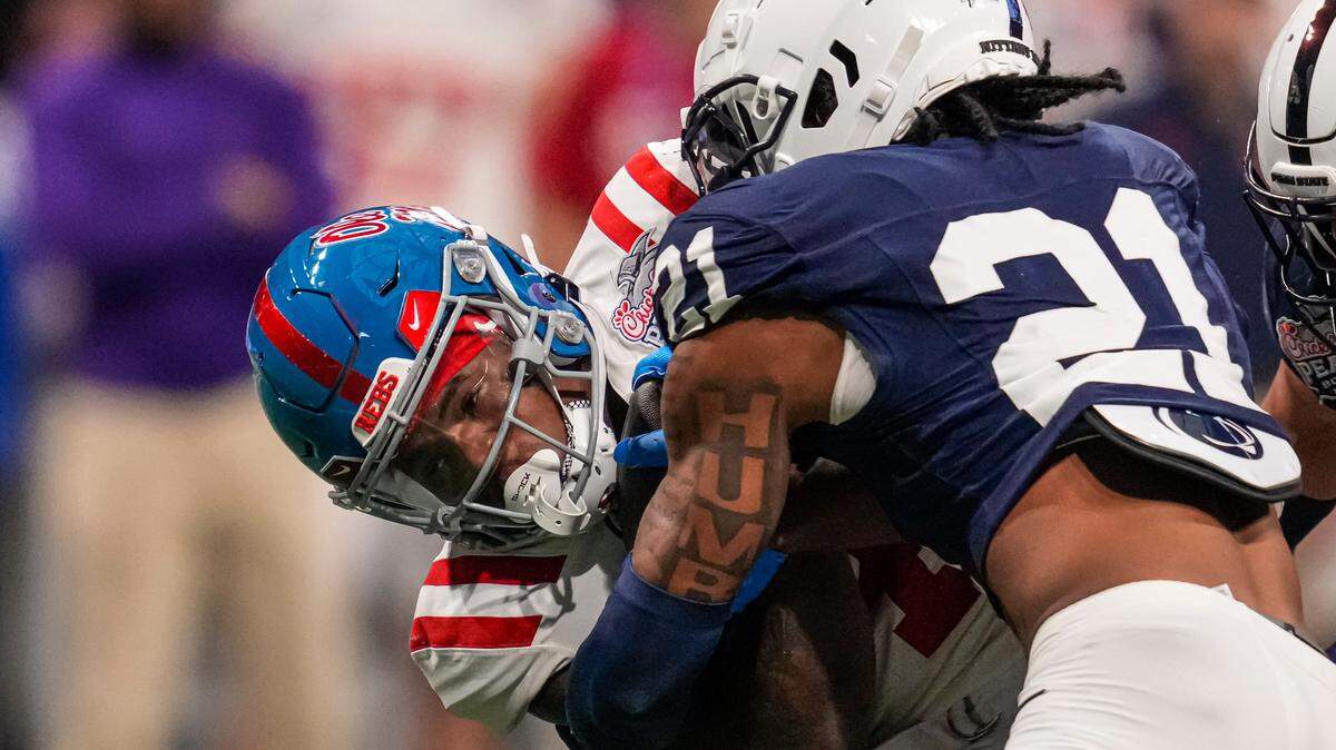 Mississippi Rebels running back Quinshon Judkins (4) is tackled by Penn State Nittany Lions safety Kevin Winston Jr. (21) during the second half at Mercedes-Benz Stadium.