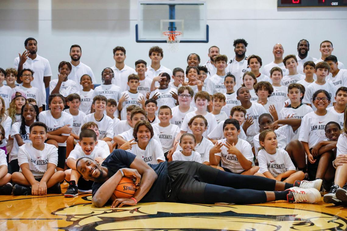 Miami Heat center Bam Adebayo is photographed lying down with a basketball in front of a group of campers during Bam Adebayo’s fourth annual youth basketball clinic at Riviera Preparatory School in Miami on Saturday, July 30, 2022.