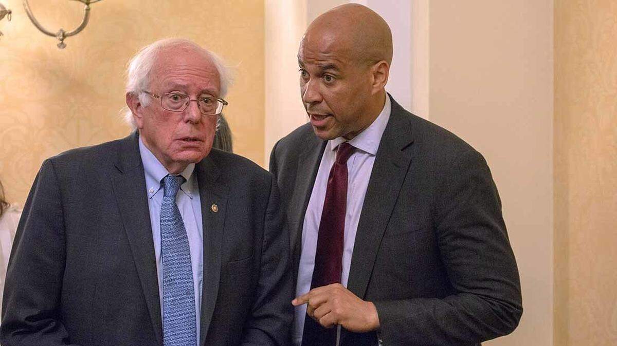 Sens. Bernie Sanders, left, and Cory Booker are among more than 20 candidates seeking the Democratic nomination for president.