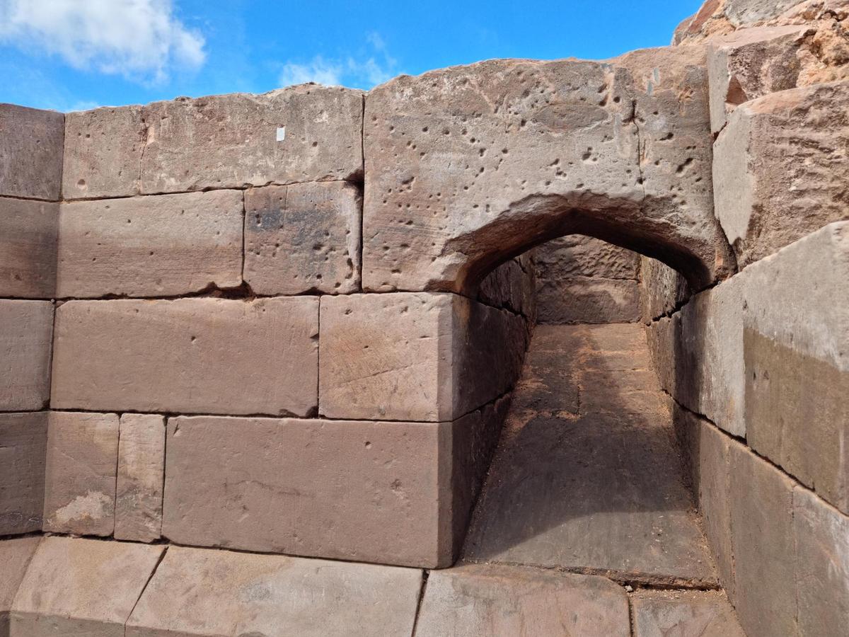 A gatehouse dorway with bullet marks along the top.