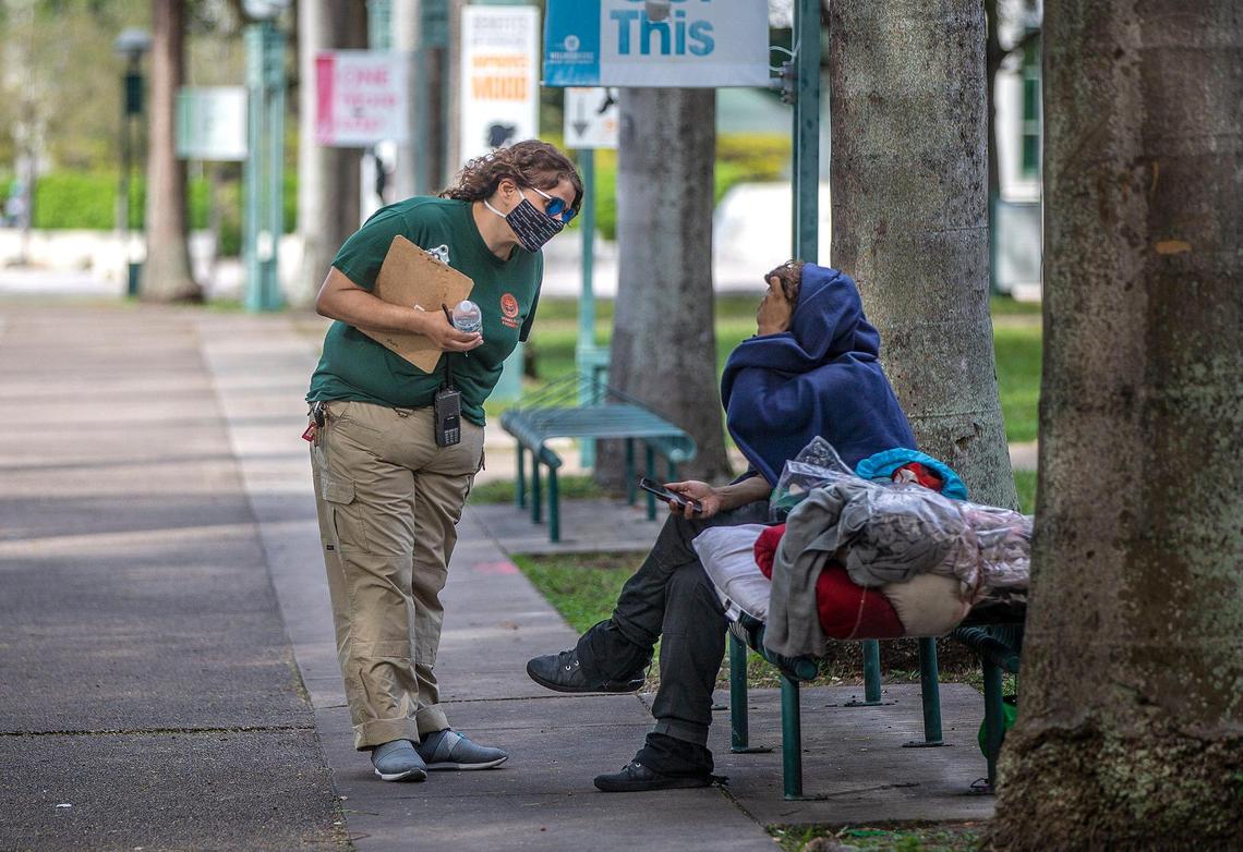 Maxie Espinosa, City of Miami outreach referral specialist, tries to persuade a homeless person in downtown Miami to be taken to shelter to stay ahead of the chilly weekend on Friday, Jan. 28, 2022.