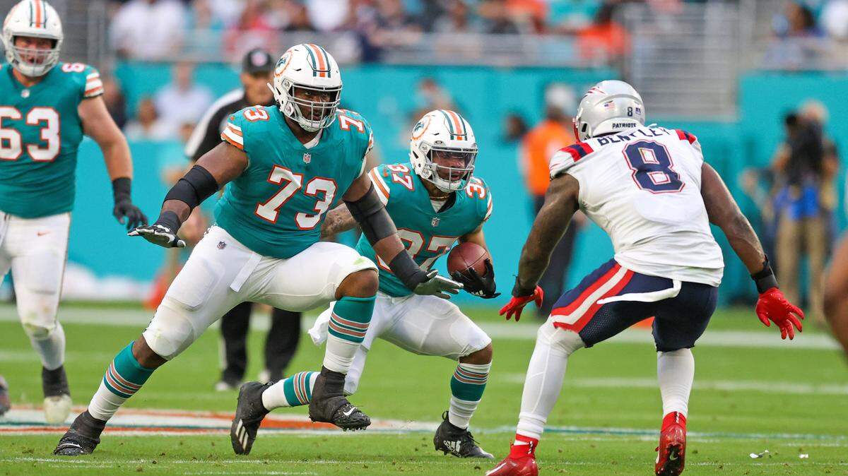 Miami Dolphins tackle Austin Jackson (73) blocks New England Patriots middle linebacker Ja’Whaun Bentley (8) as Dolphins running back Myles Gaskin (37) runs with the football during the first quarter of an NFL football game at Hard Rock Stadium on Sunday, January 9, 2022 in Miami Gardens, Florida. (David Santiago Photo / Miami Herald)