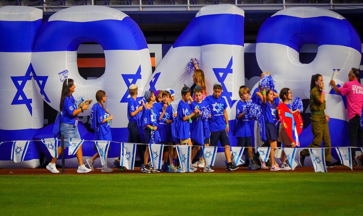 Students from Scheck Hillel Community School parade in front of “1948” inflatable as adults hold up the sign at the Marlins baseball stadium in Miami.