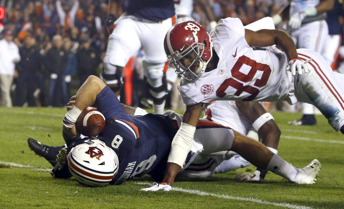 Auburn quarterback Jarrett Stidham (8) scores a touchdown as Alabama defensive back Levi Wallace (39) defends during the second half of the Iron Bowl NCAA college football game, Saturday, Nov. 25, 2017, in Auburn, Ala. (AP Photo/Butch Dill)