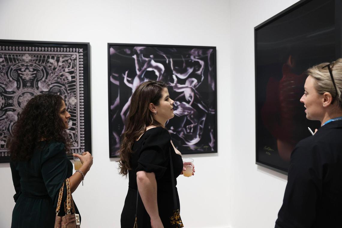 Kristen Khoury, left, and Cristina Fernandez admire artwork during the opening night of VIP for Art Miami on Tuesday, Nov. 29, 2022, at CONTEXT Art Miami.