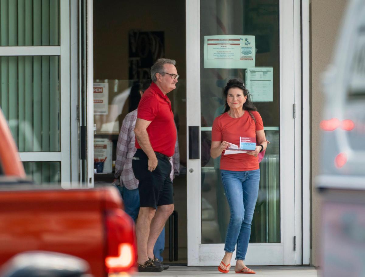 FILE - Voters exit the polls after casting their ballots on the first day of early voting at the Supervisor of Elections Main Office in West Palm Beach, Fla., on Oct. 24, 2022. Election officials in some Florida counties urged people to vote early Sunday, Nov. 6, where possible as a potential tropical system threatens the state on Election Day. The Palm Beach County elections supervisor, Wendy Sartory Link, said voters who want to avoid weather-related disruptions should cast their ballots by 7 p.m. Sunday. (Greg Lovett/The Palm Beach Post via AP, File)