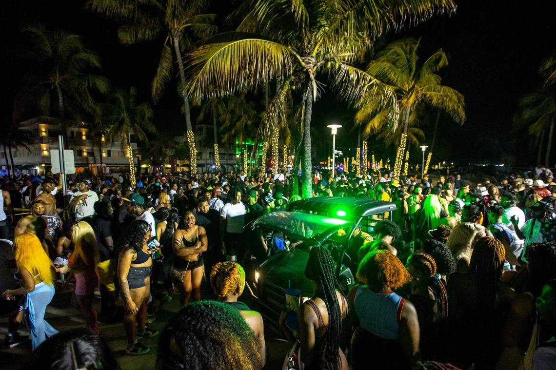 A Miami Beach Police vehicle cuts through crowds near Ocean Drive during Spring Break in Miami Beach, Florida, on Saturday, March 19, 2022.