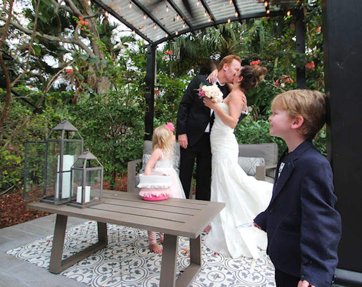 Dr. Starr Mautner, a breast surgical oncologist at Miami Cancer Institute, kisses her husband Michael Mautner as they recreate a wedding in quarantine for their children, Arie, 5, and Silver, 3. The family was planning to attend a wedding before it was canceled over concerns of COVID-19 spread.
