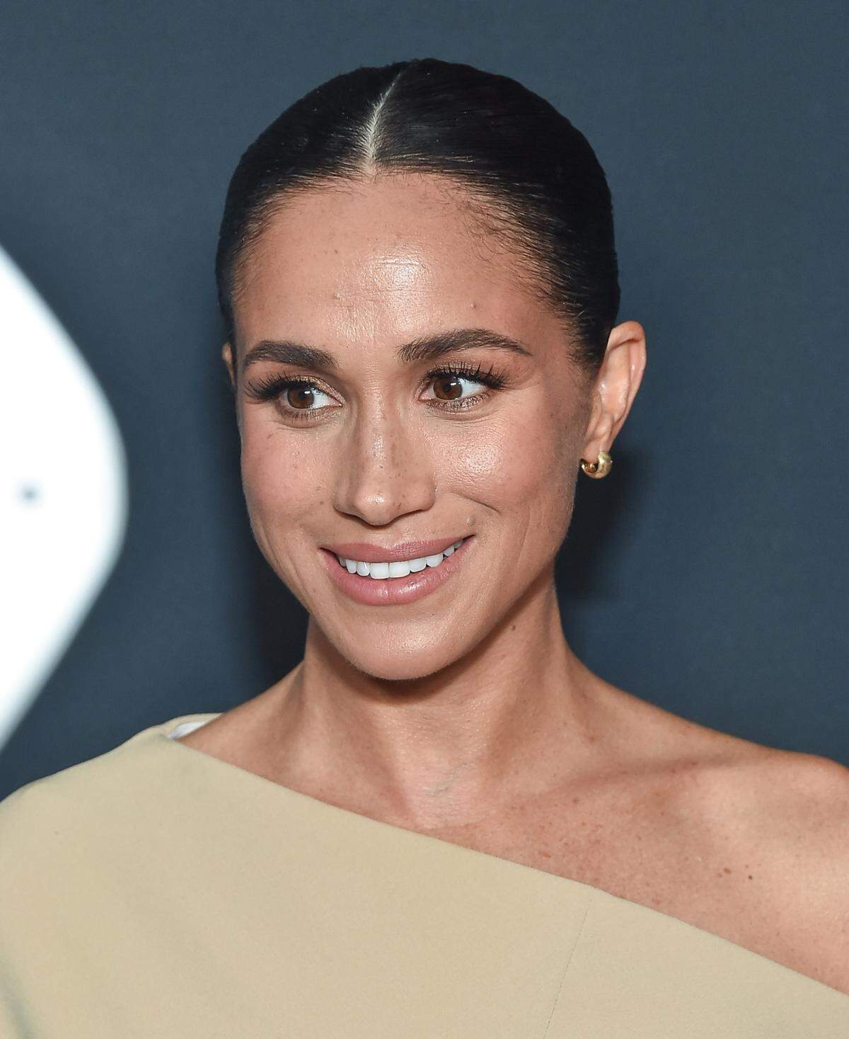 Meghan Markle smiles while on a red carpet in November.