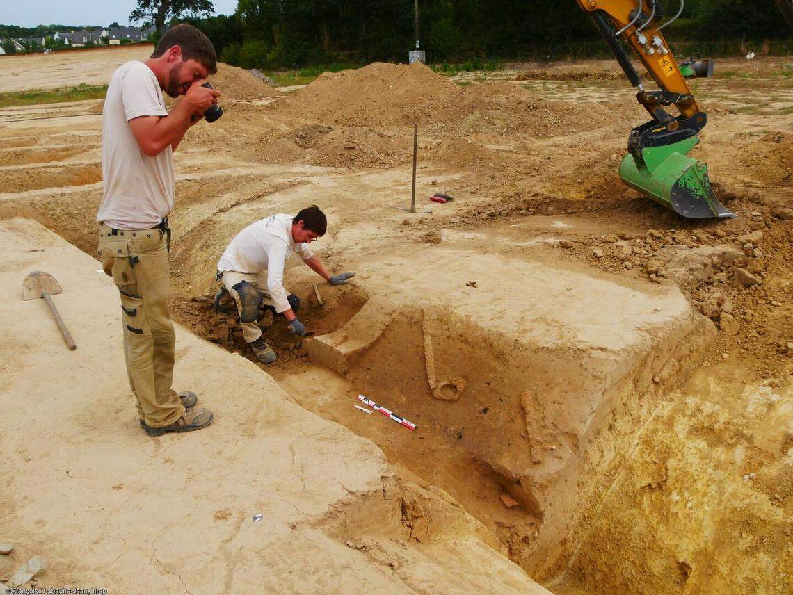 Archaeologists photographing and excavating a ditch at the sanctuary.