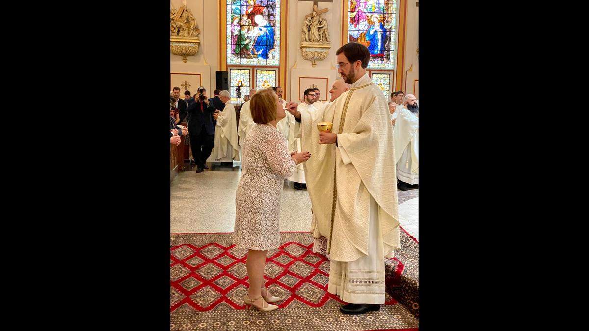Jesuit Father Julio Minsal-Ruiz gives his mother, Sarabel Ruiz-Cestero communion at the Mass of his priesthood ordination on Jan. 11, 2020, at Gesu Catholic Church in downtown Miami.