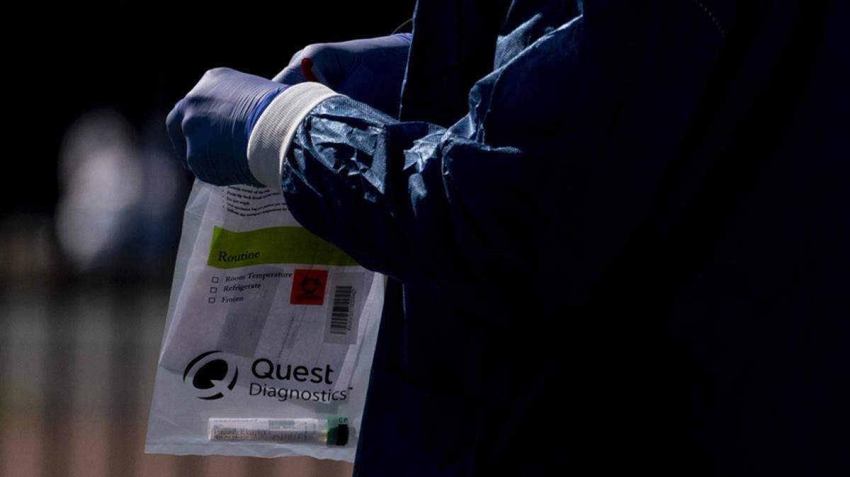 A Children’s National Hospital healthcare worker holds a Quest Diagnostics bag containing a Covid-19 swab at a coronavirus drive-thru testing site at Trinity Washington University in Washington, D.C., U.S., on Thursday, April 2, 2020. The White House’s presentation of projections for coronavirus fatalities to extend into the start of the summer will reinforce fears for extended shutdowns that spur deep declines in U.S. output and employment. Photographer: Andrew Harrer/Bloomberg via Getty Images