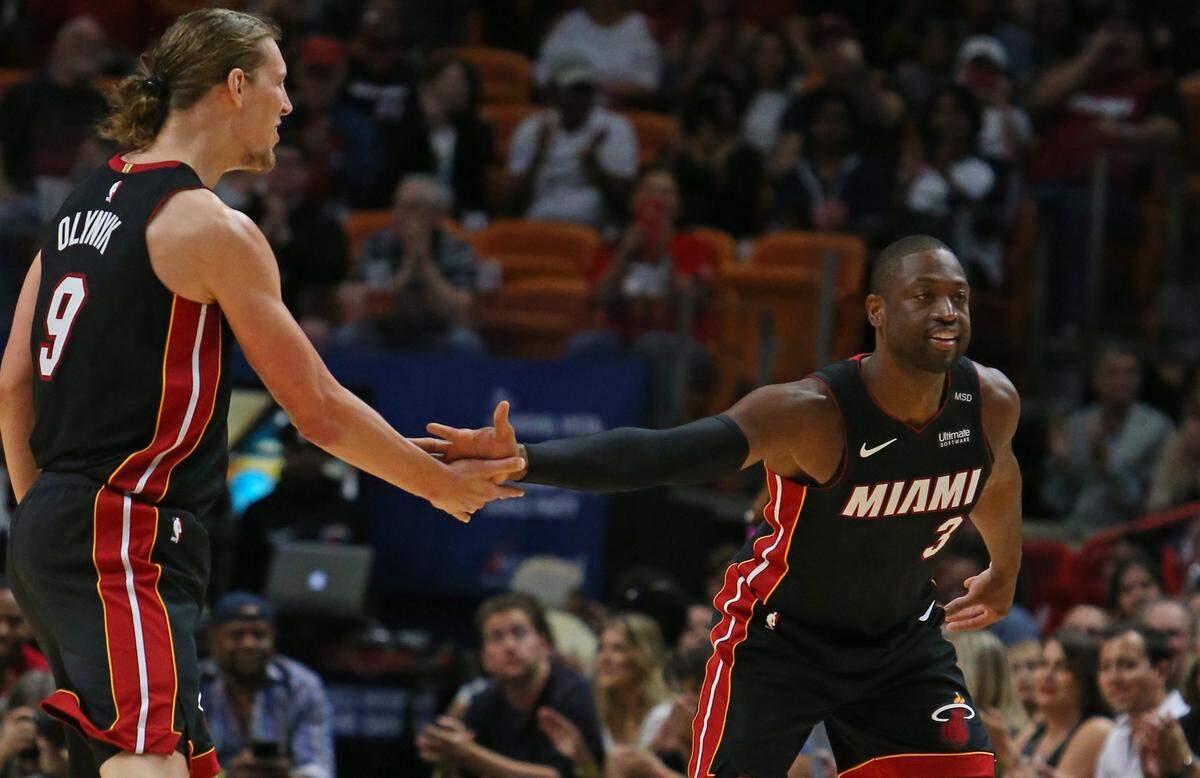 Miami Heat guard Dwyane Wade is congratulated by teammate Miami Heat center Kelly Olynyk after hitting a three-pointer against Brooklyn Nets guard Spencer Dinwiddie during the first quarter of an NBA basketball game at the AmericanAirlines Arena in Miami on Saturday, March 31, 2018.