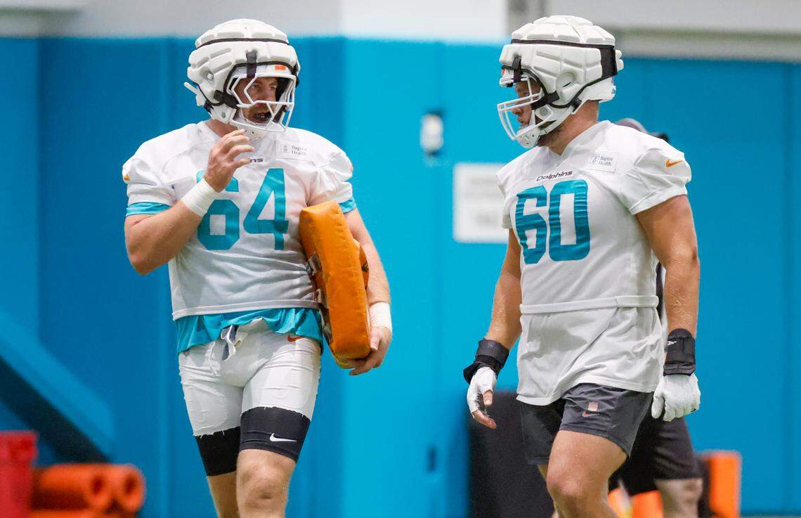 Miami Dolphins Daniel Brunskill (64) and Miami Dolphins center Andrew Meyer (60) interact during practice at Miami Dolphins Training Camp in Miami Gardens, Florida, on Wednesday, July 23, 2025. 