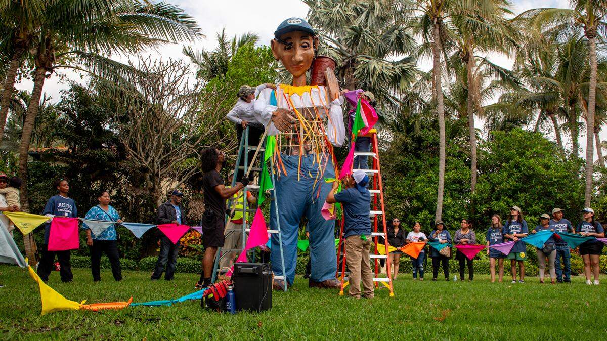 Farmworkers brought a 15-foot puppet right outside of the boardchair of Wendy’s, Nelson Peltz, mansion at Tanger Park in Palm Beach to ask him to pledge to purchase only from suppliers who follow a code of conduct designed to protect workers’ rights. They tie bandanas around the puppet, named Esperanza, that have messages written in Spanish and English calling for freedom, justice and to boycott Wendy’s. Farmworkers use bandannas to protect themselves from the sun, chemicals and for more privacy.
