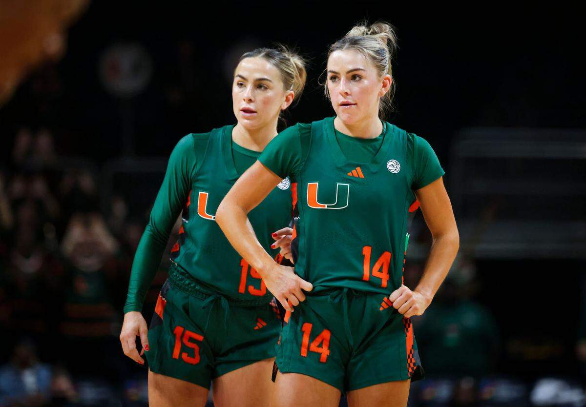 Miami Hurricanes guard Hanna Cavinder (15) whsipers something to her sister guard Haley Cavinder (14) during the fourth quarter of a game on Sunday, Feb. 16, 2025, at Wastco Center in Coral Gables, Fla. The Hurricanes lost 82-83 in the last few seconds.