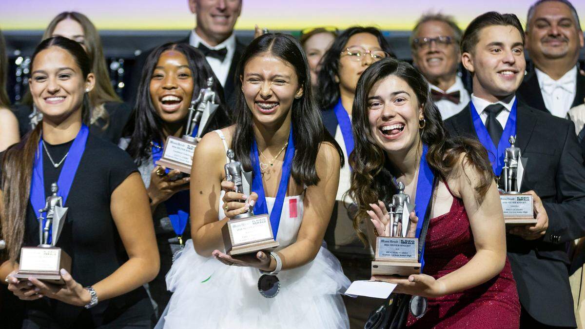 Emily Moreno, center-left, and Heather Suarez, center-right, celebrate on stage after receiving their awards during the Miami Herald & el Nuevo Herald 66th Silver Knight Award Ceremony at the James L. Knight Center on Wednesday, May 22, 2024, in downtown Miami, Fla.