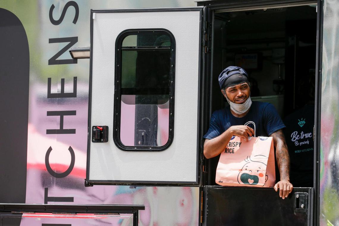 Josias Wilson waits to hand out an order of food from Krispy Rice to a driver for delivery at the REEF Hub south of Brickell.