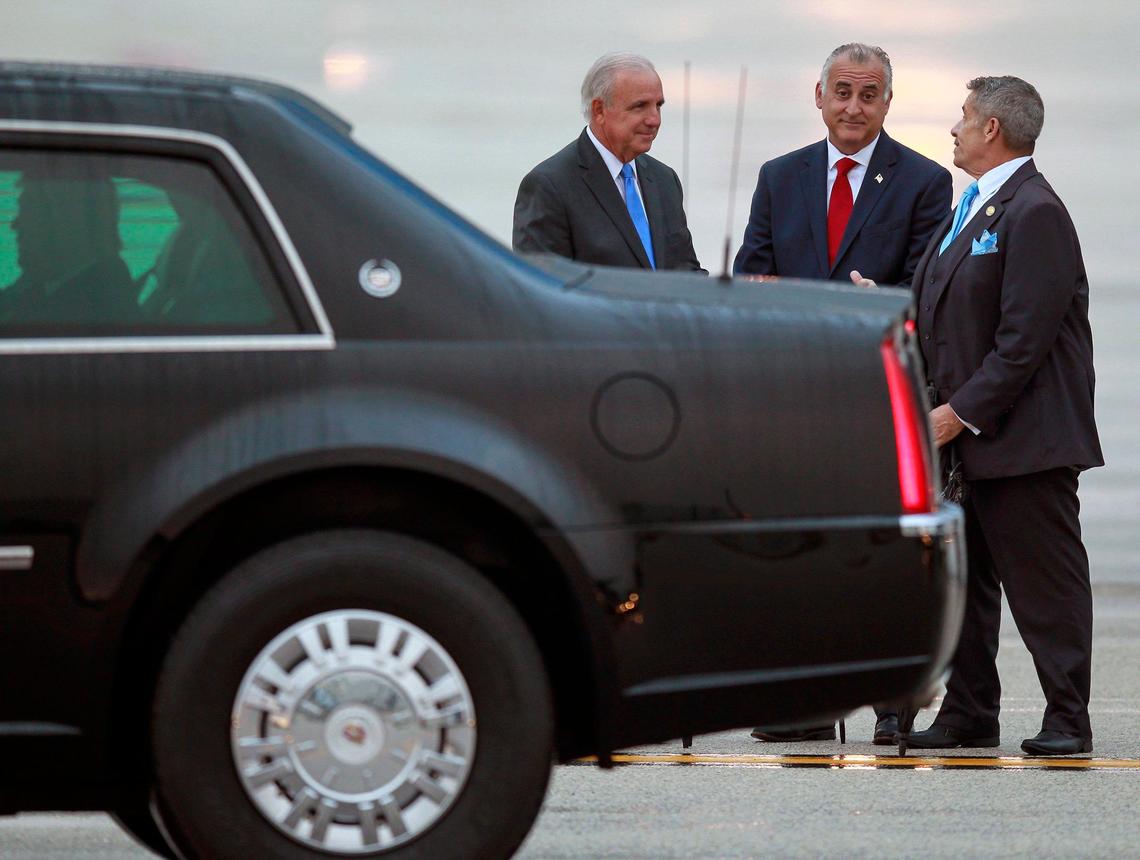 President Donald Trump, left, sits in the back of the presidential limousine while departing after Miami-Dade Mayor Carlos Gimenez, and county commissioners Esteban “Steve” Bovo and Jose “Pepe” Diaz, right, greeted Trump at Miami International Airport on Thursday, January 23, 2020.
