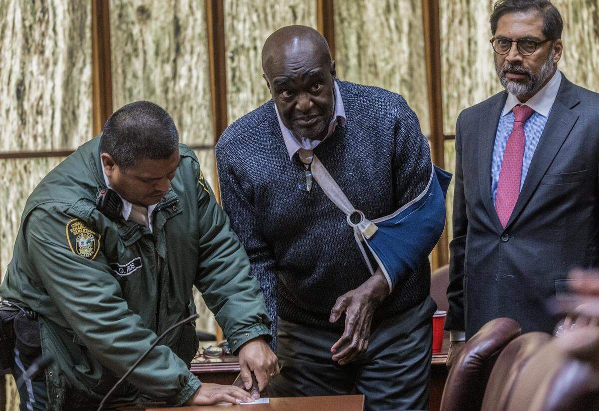 Defense attorney Khurum Wahid, right, looks on as Harrel Braddy, convicted of leaving a 5-year-old girl to die in the Everglades in 1998, has his fingerprints taken by a corrections officer after being sentenced to life in prison in his death-penalty resentencing trial in Courtroom 4-1 at the Richard E. Gerstein Justice Building, Friday, Jan. 30, 2026.
