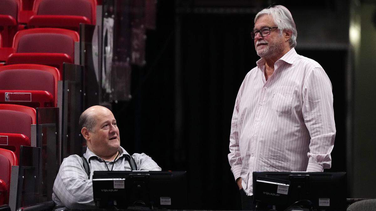 Miami Heat owner Micky Arison (R) talks with general manager Andy Elisburg (L) prior to the game between the Miami Heat and the Charlotte Hornets at Kaseya Center.