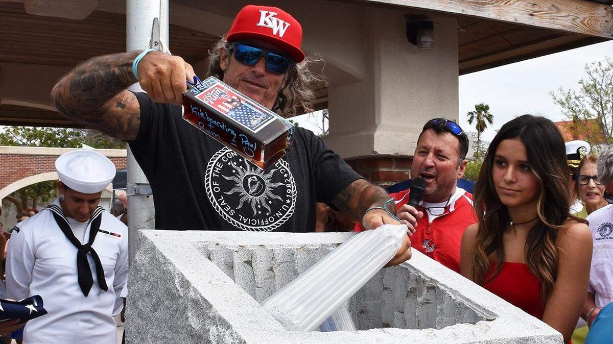 Paul Menta, chairman of the Key West bicentennial celebration committee, adds a bottle of rum to the time capsule sealed on March 25, 2022.