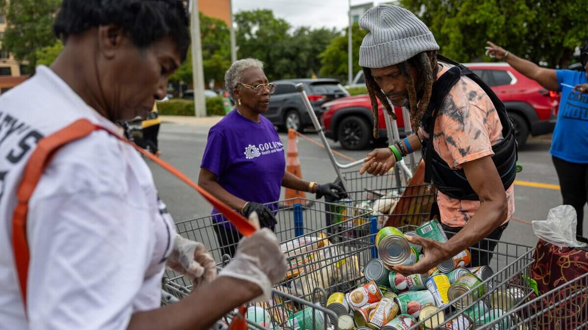 Volunteers Elma Foster, left, and Mary Beasley work alongside a food bank recipient at Curley’s House Food Bank in Miami on Thursday, June 4, 2026.