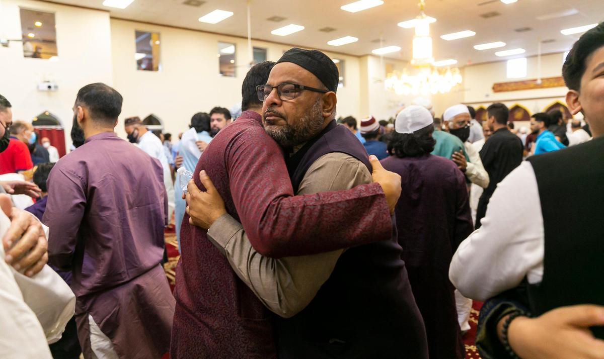 Shakir Khan, center-right, celebrates after performing the Eid al-Adha prayer at the Islamic Center of Greater Miami on Saturday, July 9, 2022, in Miami Gardens, Fla.