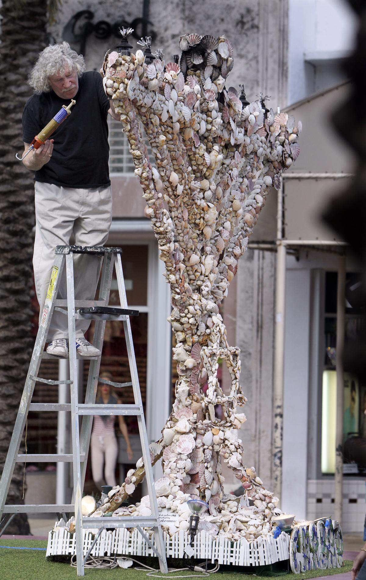 Roger Abramson working on his shell menorah at Euclid and Lincoln Road Mall on Dec. 19, 2011. The delicate seashells that covered its surface would often crack or fall off. 