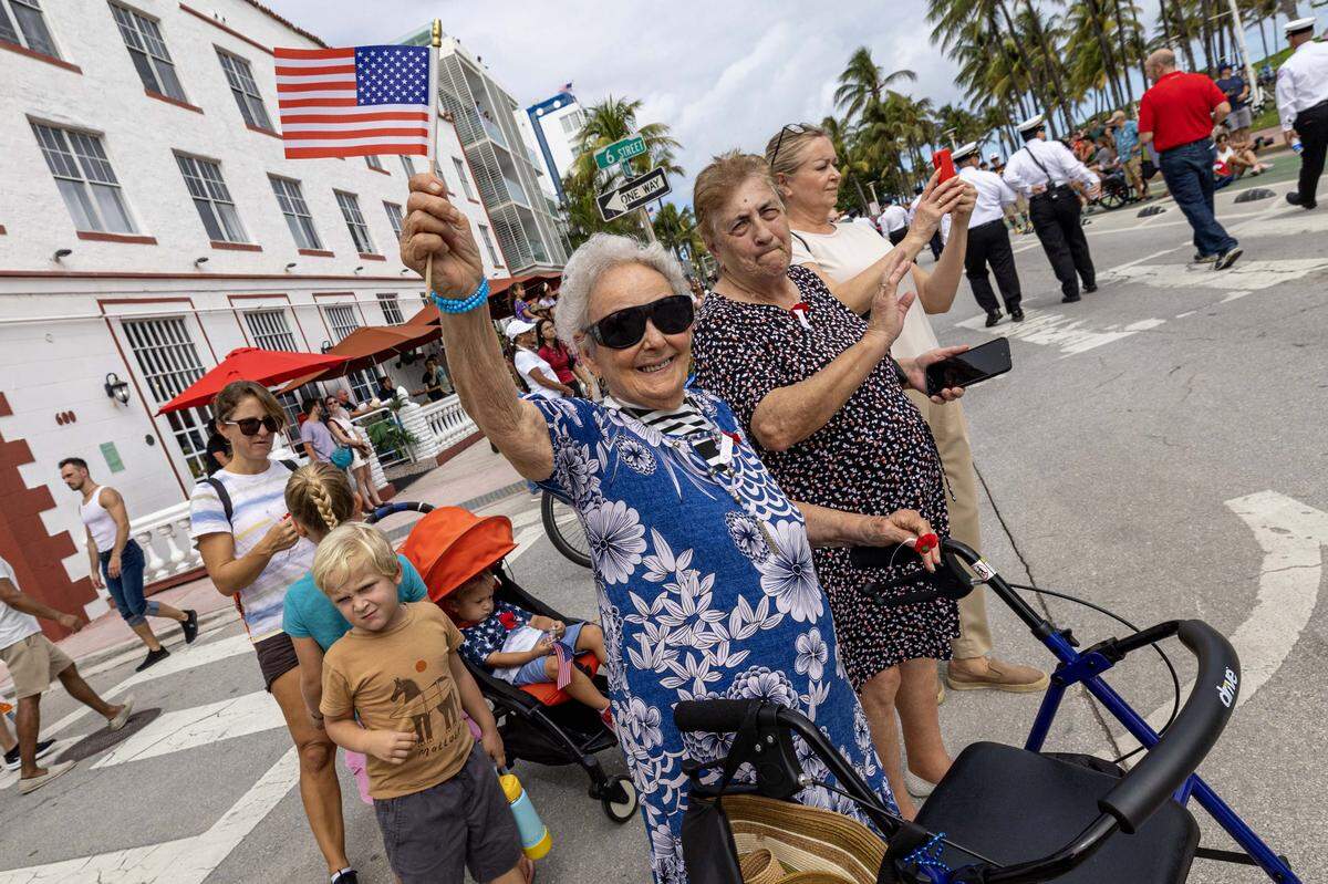 Josephina Gonzalez waves a flag during the Veterans Day parade in 2024 in Miami Beach.