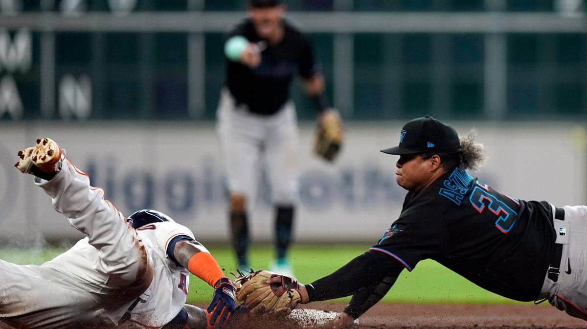 Houston Astros’ Martin Maldonado, left, is tagged out at second base by Miami Marlins second baseman Willians Astudillo (37) while trying to stretch a single into a double during the third inning of a baseball game Saturday, June 11, 2022, in Houston. (AP Photo/David J. Phillip)